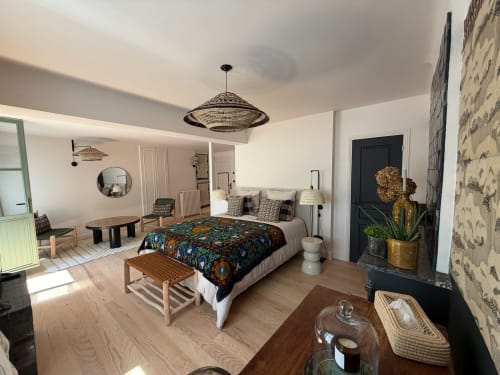 Chambre Balthazar à la Maison Romy B&B : Chambre moderne avec literie aux motifs colorés, mobilier en bois, éclairage suspendu