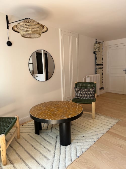 Chambre Balthazar à la Maison Romy avec miroir rond, luminaire suspendu tissé, table basse à motifs et décoration vue sur la ville