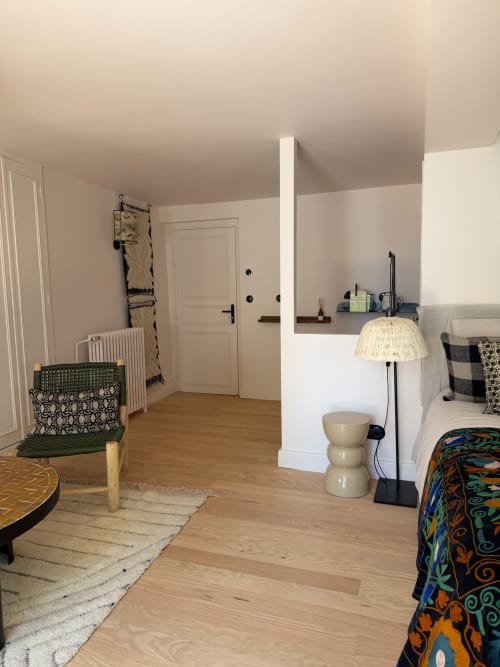 Suite Balthazar Maison Romy : parquet, lit aux teintes chaleureuses, cloison blanche, vue panoramique sur la ville depuis le balcon