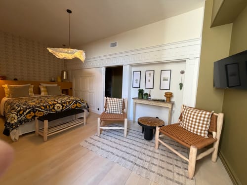 Chambre de la Maison Romy avec lit, cheminée, fauteuils et vue sur le jardin en France