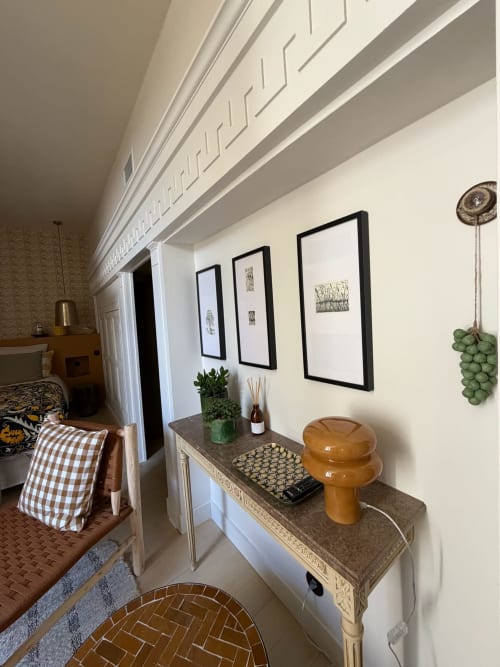 Chambre apaisante Maison Romy avec vue sur le jardin, art botanique encadré, console décorée et espace détente accueillant.