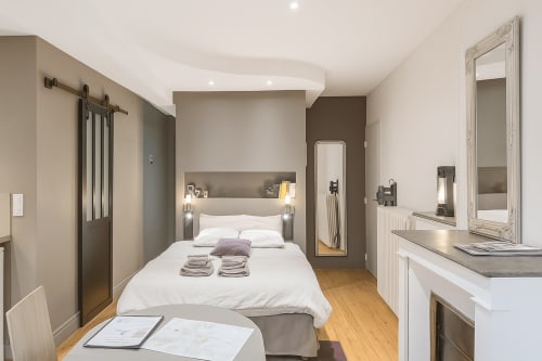 Chambre moderne du Maunoury Citybreak à Chartres avec literie blanche, tête de lit noire, parquet et vue sur le jardin