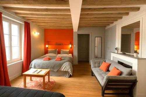Appartement Maunoury à Chartres avec murs orange, poutres bois, lit queen, canapé et vue sur jardin
