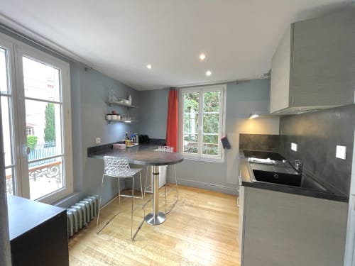Cuisine moderne avec coin bar dans l'appartement Maunoury Citybreak à Chartres, équipée d'appareils en acier inoxydable et jardin
