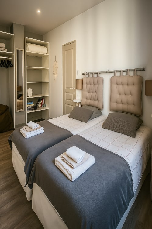 Lits jumeaux aux têtes de lit matelassées dans une chambre moderne de l'appartement Maunoury Citybreak à Chartres, avec rangements intégrés et