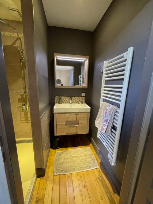 Salle de bains moderne à l'hôtel Maunoury Citybreak à Chartres : meuble en bois, sèche-serviettes et douche à l'italienne