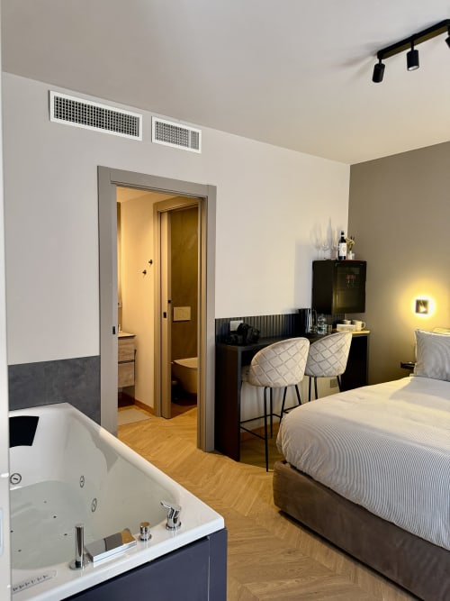 Camera moderna a Casa Giulietta a Como con vasca idromassaggio, letto, scrivania e bagno privato con vista sul lago
