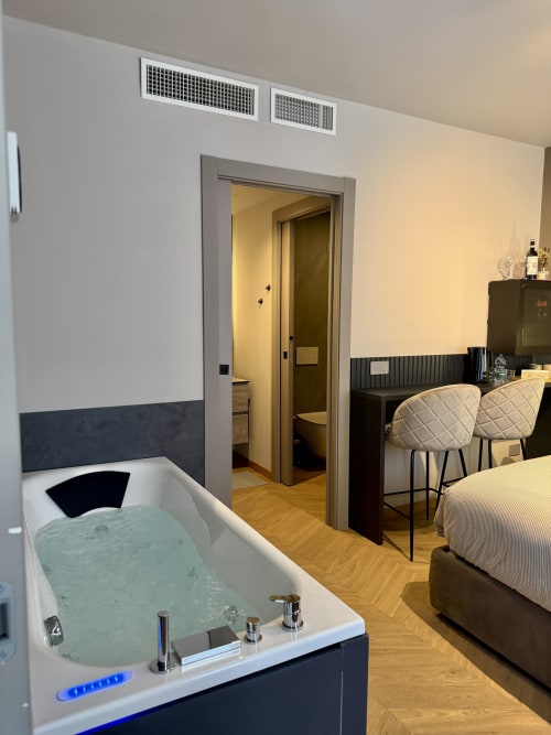 Esclusiva suite camera da letto a Casa Giulietta a Sirmione con vasca Jacuzzi illuminata, letto e bagno ensuite