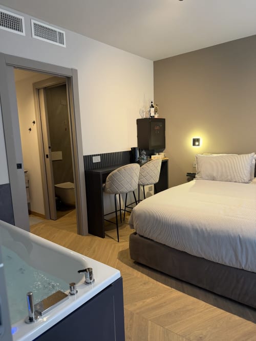 Camera moderna presso Casa Giulietta a Como con letto, scrivania di lavoro, bagno privato e vasca idromassaggio con vista sul lago