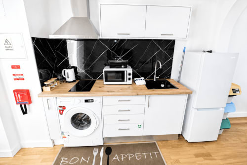 Cozinha moderna na villa Atlantic Escape, Funchal, com painel traseiro de mármore preto, bancadas de madeira e eletrodomésticos brancos