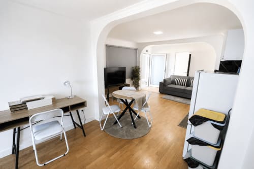 Sala moderna em Funchal com mesa de jantar, espaço de trabalho, sofá, cozinha compacta e janelas com vista para o mar