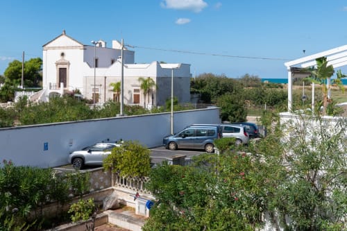 Hotel Porticicolo Vacanze a Villanova con edifici bianchi, parcheggio, vista mare e giardini mediterranei