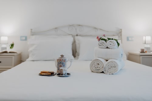 Accogliente camera da letto a Il Porticciolo con asciugamani arrotolati, servizio té e vista sul mare dall'appartamento di Villanova