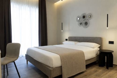 Modern double bedroom at Mas Collection Bari with gray upholstered bed, city balcony access, and contemporary decor