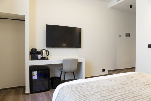 Camera moderna a Bari con letto matrimoniale, TV a parete, scrivania con sedia e stazione caffè Mas Collection