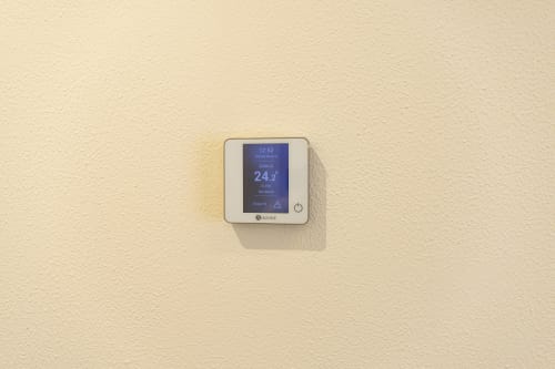 Termostato digitale Ozone che visualizza 24.2°C su parete beige nella camera dell'hotel Mas Collection, Bari