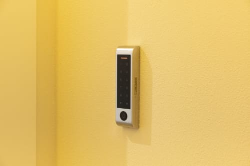 Serratura digitale a tastiera sulla parete gialla della camera d'hotel Mas Collection, Bari Italia
