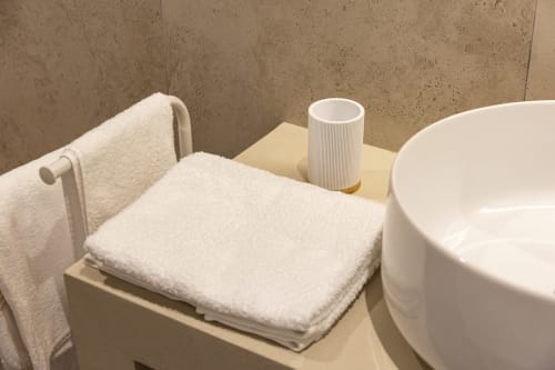 Angolo moderno del bagno con asciugamani bianchi, dispenser di amenities e vasca al Mas Collection hotel di Bari