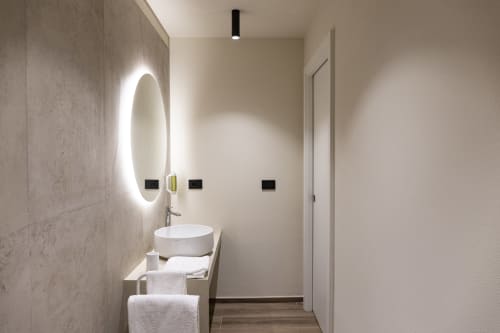 Bagno moderno nella Mas Collection hotel Bari con specchio ovale illuminato, lavabo bianco e arredamento neutro