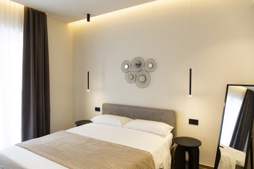 Camera moderna della Mas Collection di Bari con letto matrimoniale, testata grigia, specchi decorativi e illuminazione calda