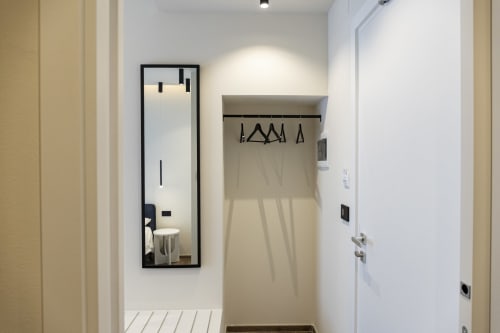 Ingresso moderno della camera d'hotel di Mas Collection Bari con specchio, armadio e porta bianca