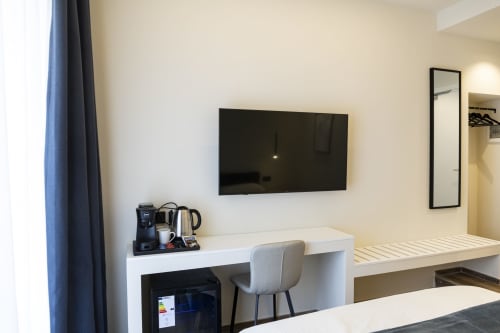 Camera moderna del Mas Collection Bari con TV a parete, scrivania, macchina da caffè e vista sulla città