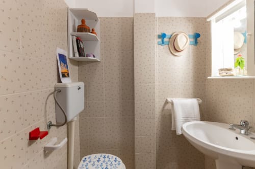 Bagno pulito con toilet, lavandino e zona doccia dell'appartamento Il Porticciolo Vacanze a Villanova