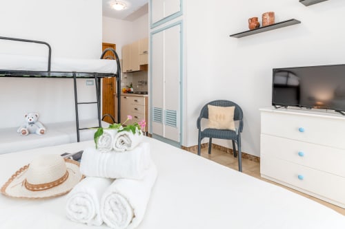Moderno monolocale a Villanova con biancheria bianca, angolo cottura, TV e letti a castello