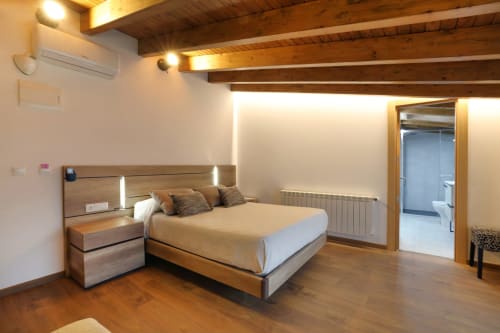 Moderno dormitorio doble en hotel Torre de Quintana en Suances con vigas de madera, cama matrimonial, baño privado y vistas al jardín