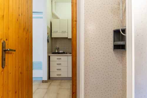 Piccola cucina con pensili color crema e piano cottura a gas nell'appartamento Il Porticciolo, Villanova