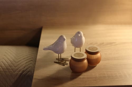 Pájaros de cerámica blanca sobre macetas de miel de madera en el hotel Torre de Quintana de Suances, decoración rústica