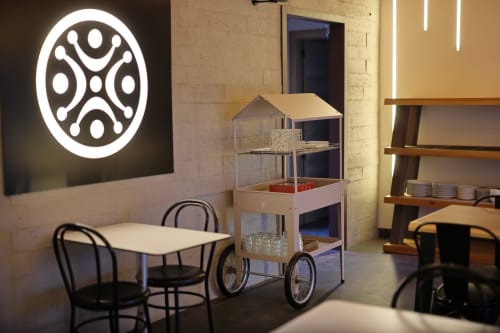 Moderno salón del hotel Torre de Quintana en Suances con arte neón, estanterías de madera y mobiliario creativo