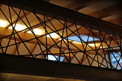 Pantalla metálica geométrica moderna en el hotel Torre de Quintana de Suances, España, con iluminación cálida y vigas de madera