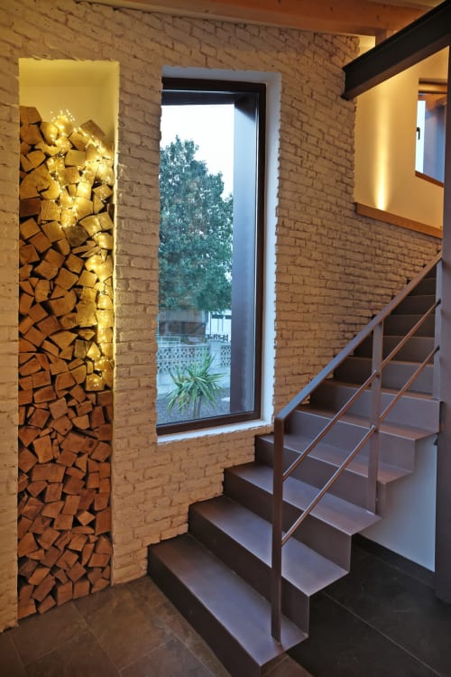 Elegante entrada del hotel Torre de Quintana con chimenea iluminada y escalera metálica