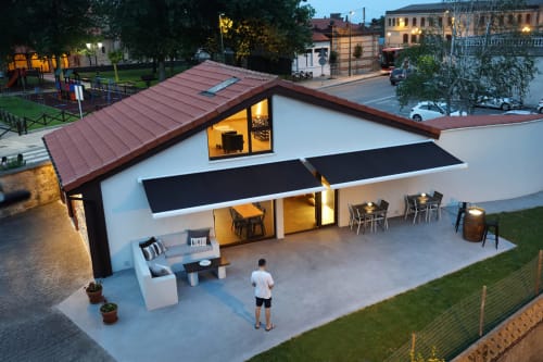Terraza moderna del hotel Torre de Quintana en Suances con edificio blanco iluminado, zona de comedor y arquitectura costera