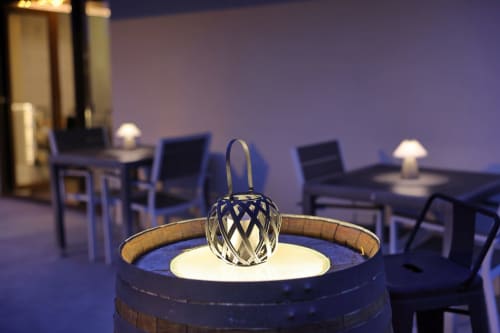 Linterna decorativa sobre barril en el hotel Torre de Quintana de Suances con zona de descanso de fondo