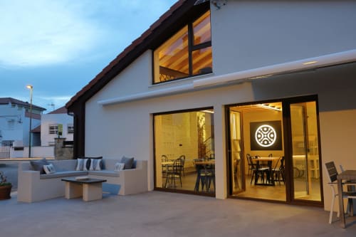 Terraza del hotel Torre de Quintana en Suances con arquitectura moderna, asientos al aire libre y comedor interior iluminado