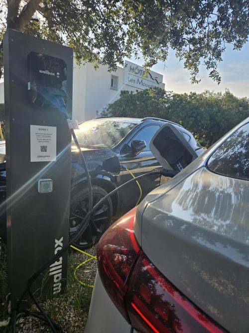 Wallbox-Ladestation für Elektrofahrzeuge im Hotel Les Mouettes in Belgodère mit angeschlossenen Fahrzeugen