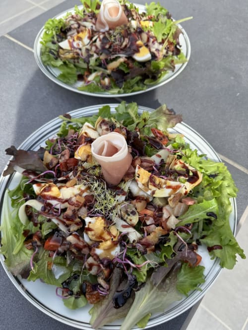Deux assiettes de salade à L'instant D'un Séjour B&B avec mesclun, légumes et garniture de jambon de Paris