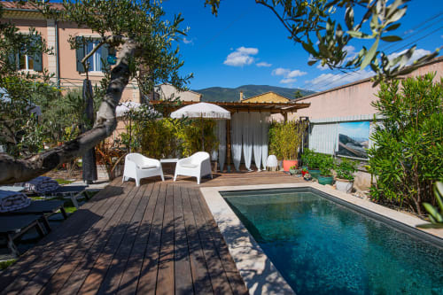 Terrasse au bord de la piscine de La Maison Gerval à Béodin, avec chaises longues, pergola et vue sur les montagnes