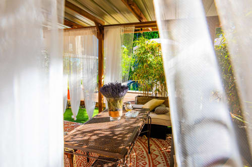 Terrasse ombragée de la Maison Gerval B&B à Bédoin avec arrangement de lavande et vue sur le jardin