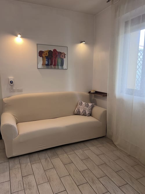 Moderno divano color crema in luminoso soggiorno con vista finestra presso l'appartamento Selva Marina Casa Vacanze, Riccione