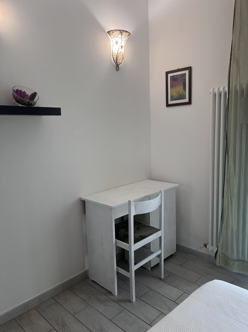 Moderna scrivania camera da letto con sedia presso l'appartamento Selva Marina Casa Vacanze a Riccione, con applique murale e vista sul giardino
