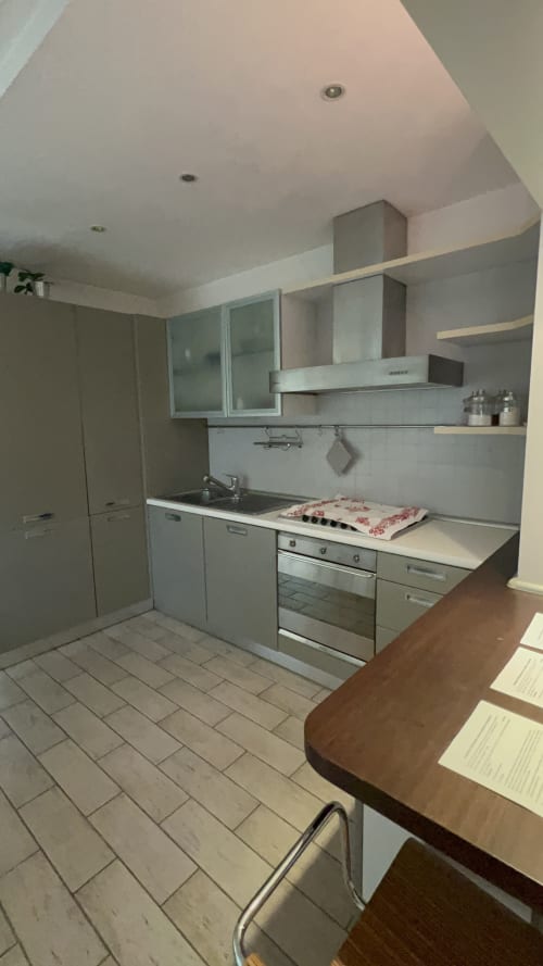 Moderna cucina dell'appartamento a Selva Marina Casa Vacanze, Riccione, con mobili bianchi, elettrodomestici in acciaio inossidabile e zona pranzo