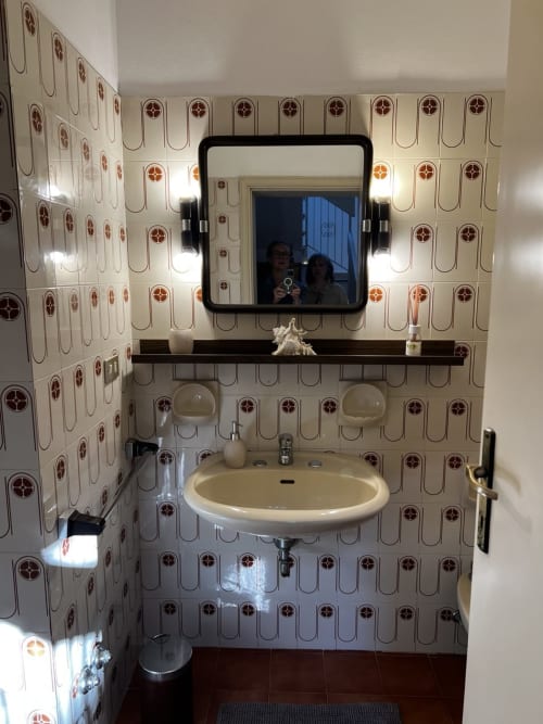 Bagno vintage della Selva Marina Casa Vacanze a Riccione con piastrelle retrò, lavabo tondo e specchio illuminato