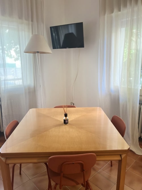 Zona pranzo dell'appartamento La Casetta Vintage presso Selva Marina Casa Vacanze, Riccione, con tavolo in legno e sedie in terracotta