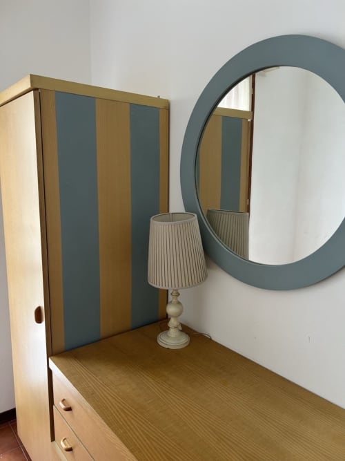 Camera da letto vintage presso Selva Marina Casa Vacanze con specchio rotondo, cassettone in legno e lampada da tavolo