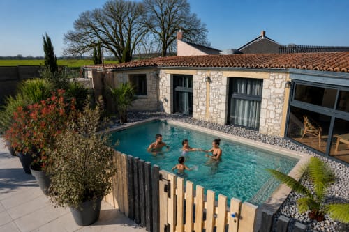Cottage Maison Azur au Clos Divin avec piscine privée, bâtisse en pierre, familles nageant dans l'eau turquoise