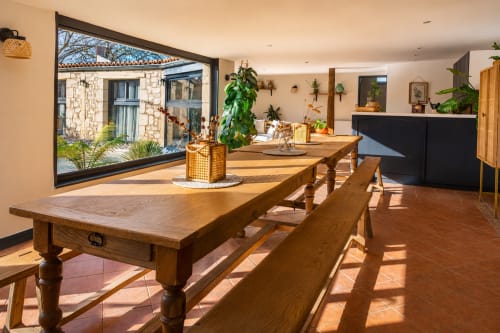 Salle à manger lumineuse du cottage Maison Azur avec table en bois, carrelage en terre cuite et grandes portes ouvertes sur le jardin