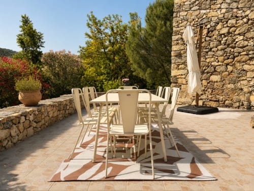 Terrasse extérieure pour dîner à la villa Santa Reparata à L'Île-Rousse avec murs en pierre et vue sur le jardin